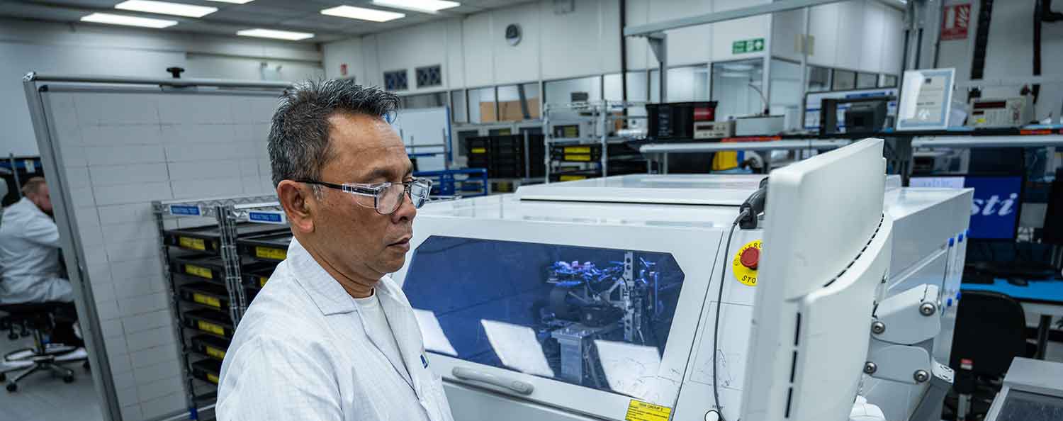 Male in labcoat looking at a screen