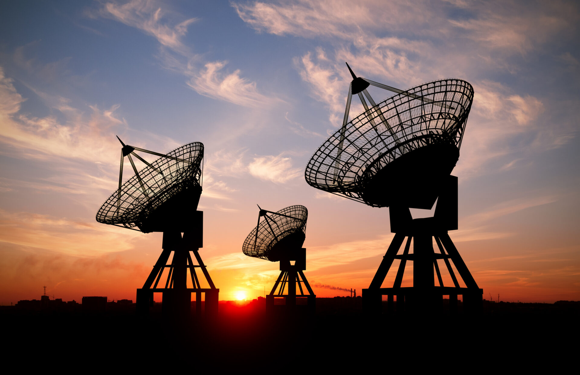 Three satelite dishes at sunset